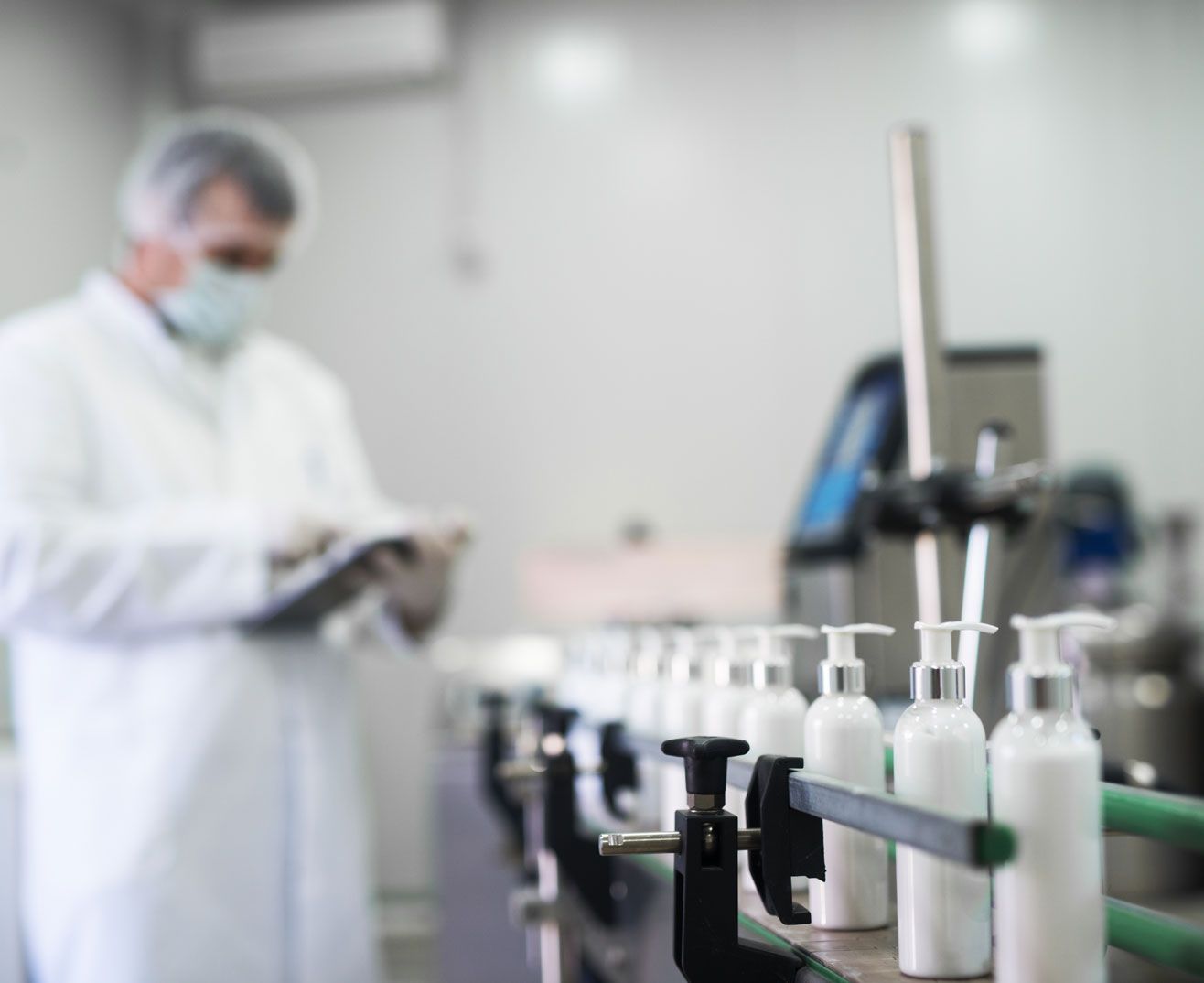 Technician quality checking a conveyor belt of bottles
